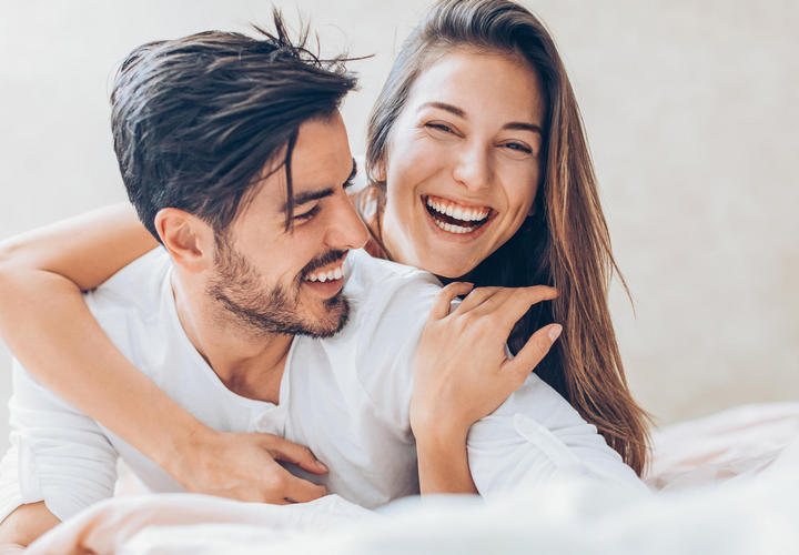 couple laughing in bed